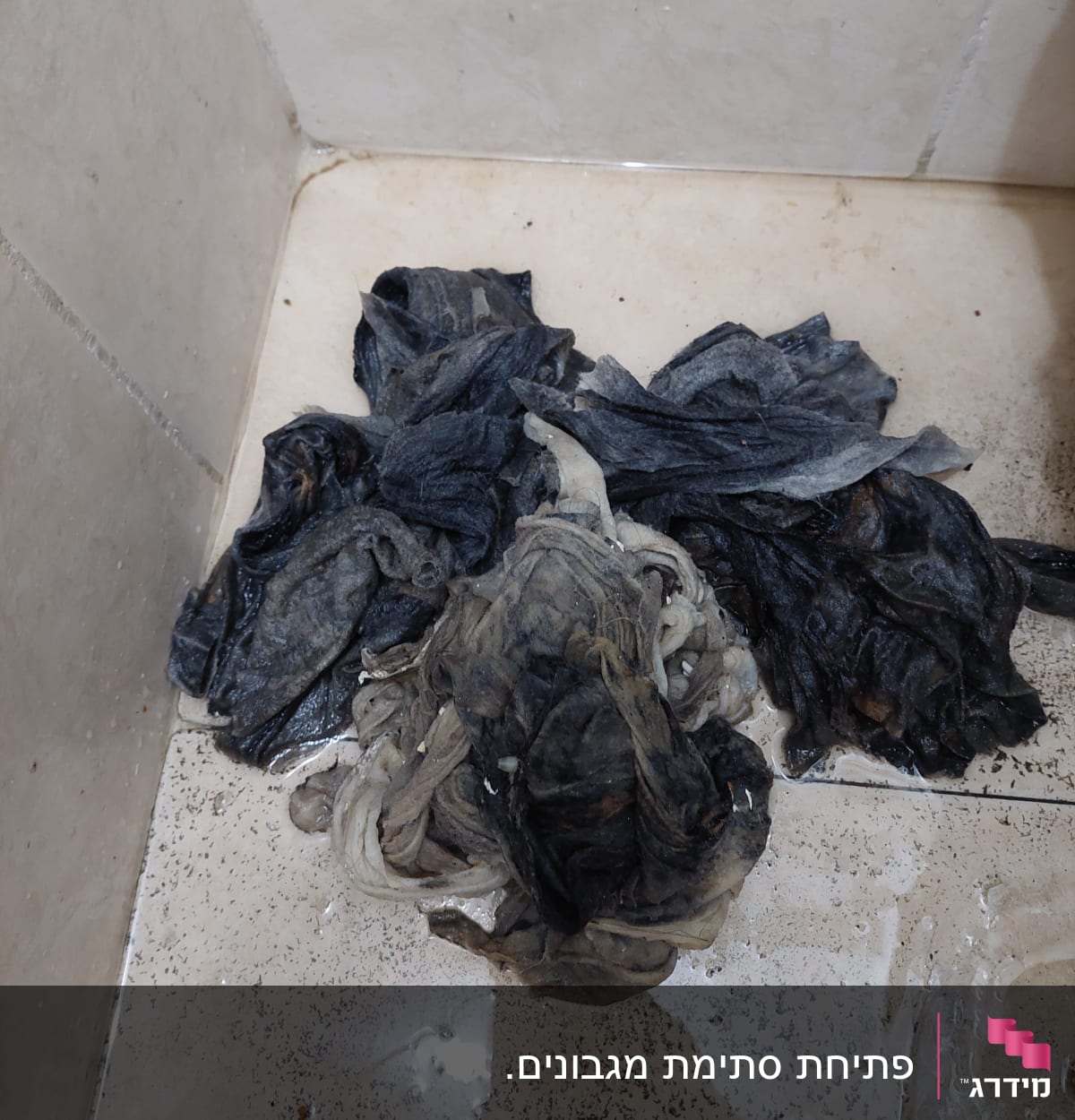 ערימת סמרטוטים רטובים על רצפת אמבטיה